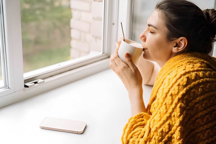 Person practicing digital minimalism with reduced screen time and a calm morning routine.