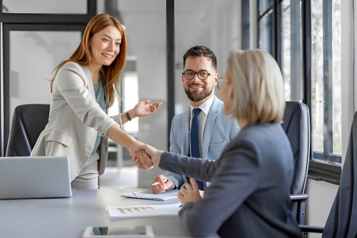 Business leaders shaking hands across a conference table.