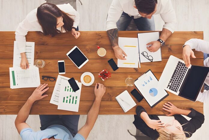 Business executives from different companies collaborating around a table.