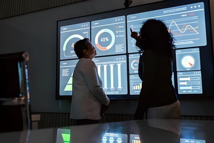 Business executives reviewing multiple future growth charts on a digital screen.