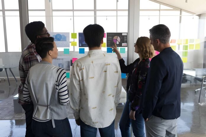 Business executives reviewing startup pitches on digital screens