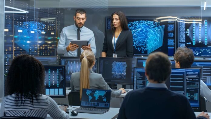 Business team analyzing data displayed on large interactive screens.