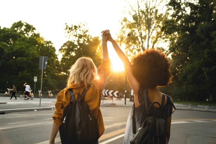 intentional friendships Friends walking together through a city park during sunset.